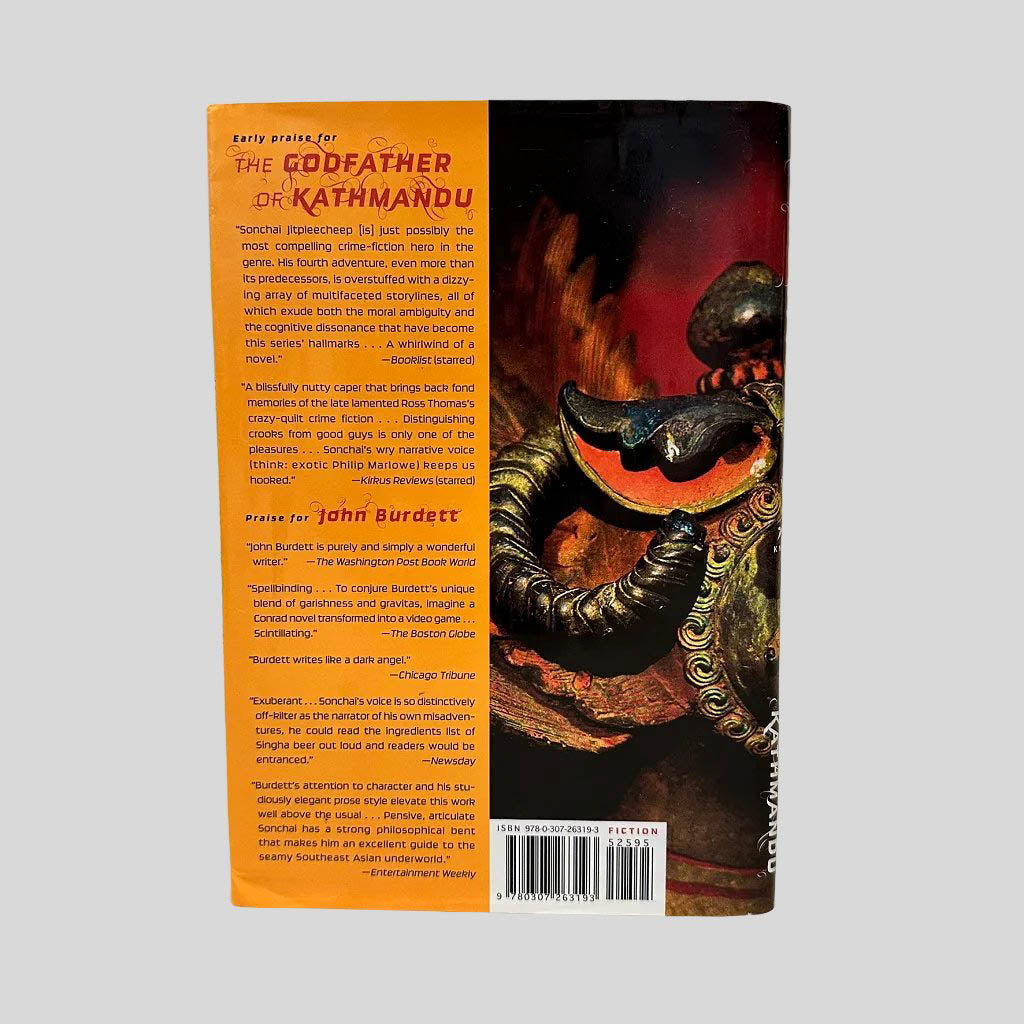 Back cover view of The Godfather of Kathmandu by John Burdett centered on a neutral light gray background. Dust jacket present and undamaged.