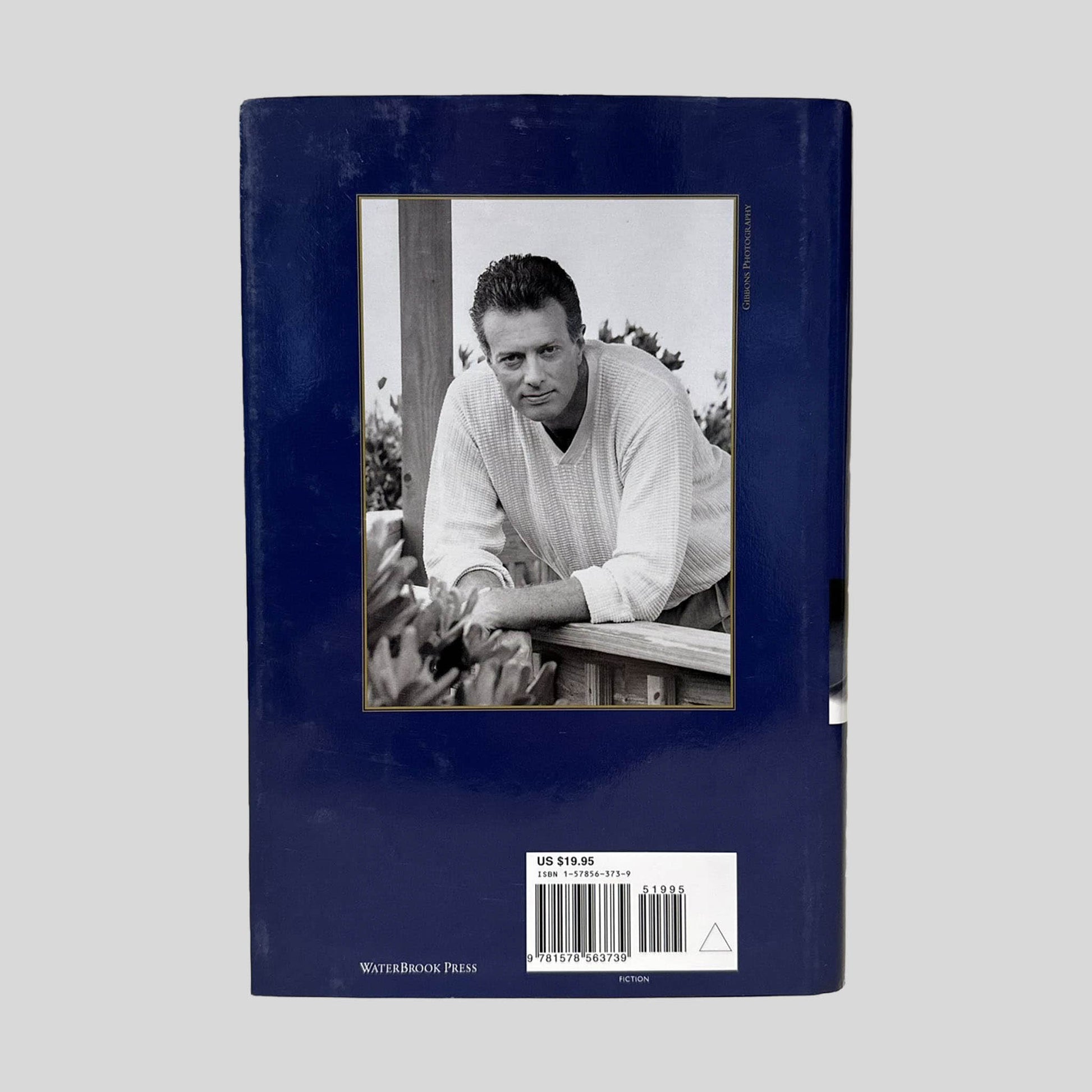 Back cover view of The Great Divide by T. Davis Bunn centered on a neutral light gray background. Dust jacket is present and no damage present.