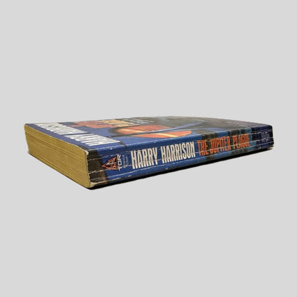 Close-up spine view of The Jupiter Plague by Harry Harrison centered on a neutral light gray background. Spine shows chipping and creasing. Pages lay flat.