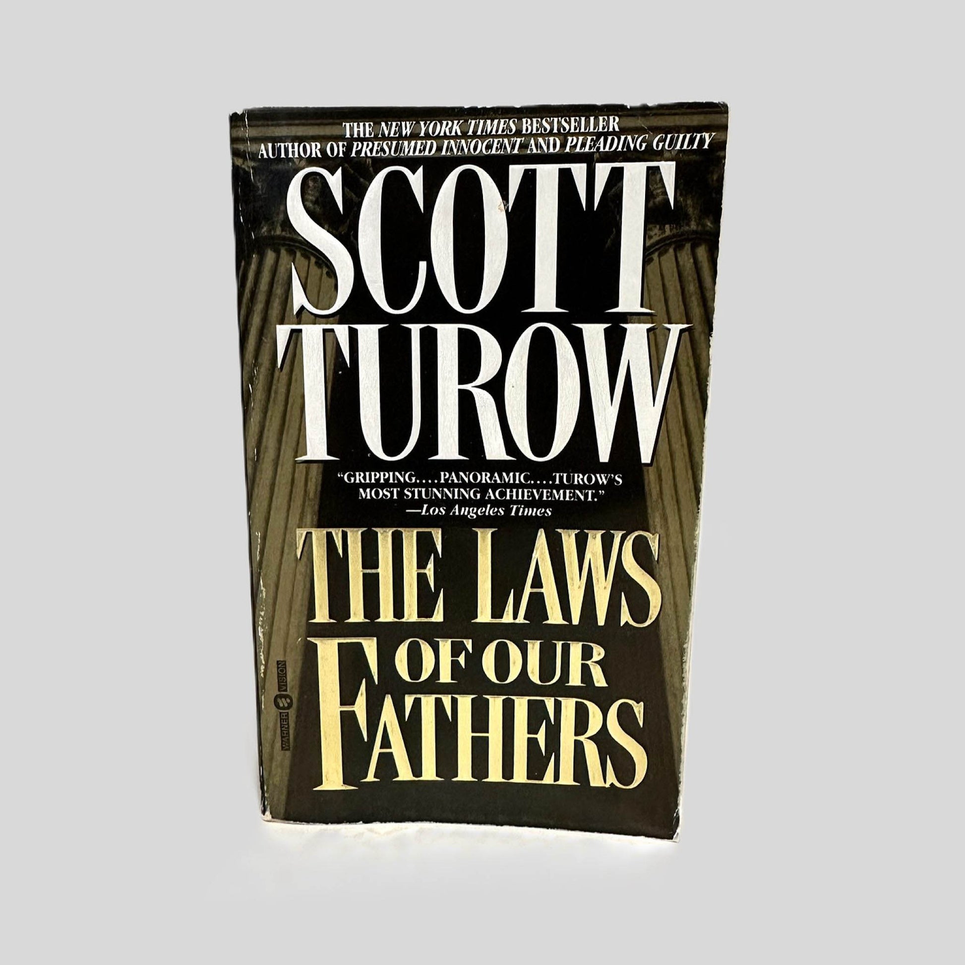 Front cover view of The Laws of Our Fathers by Scott Turow centered on a neutral light gray background. Some minor chipping around the cover edges.