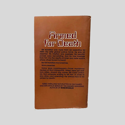 Back cover view of The Long Arm of Gil Hamilton by Larry Niven centered on a neutral light gray background. Chipping and bumping to the spine corners.