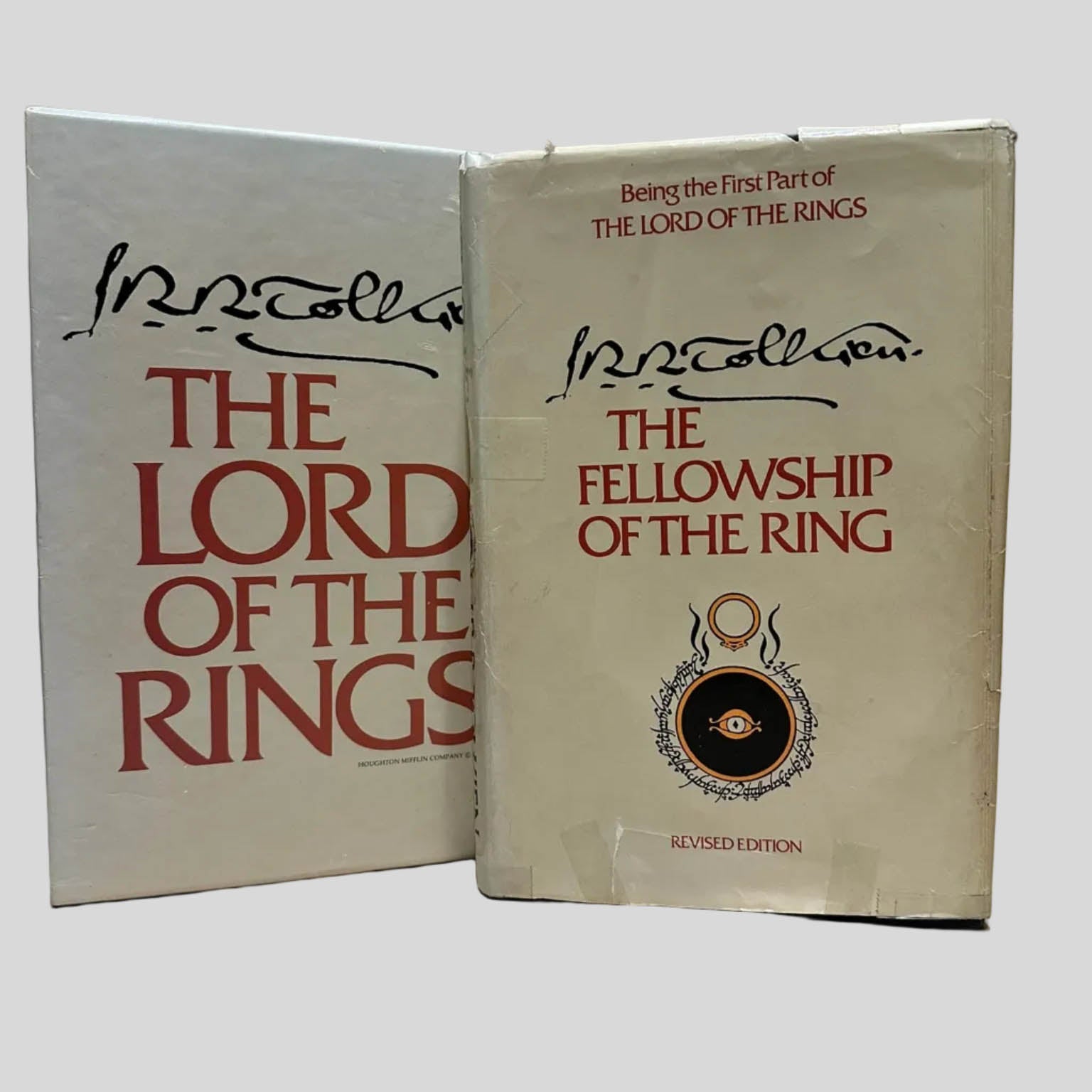 Vintage J.R.R. Tolkien slipcase next to a hardcover copy of 'The Fellowship of the Ring' featuring the iconic Eye of Sauron and red typography.