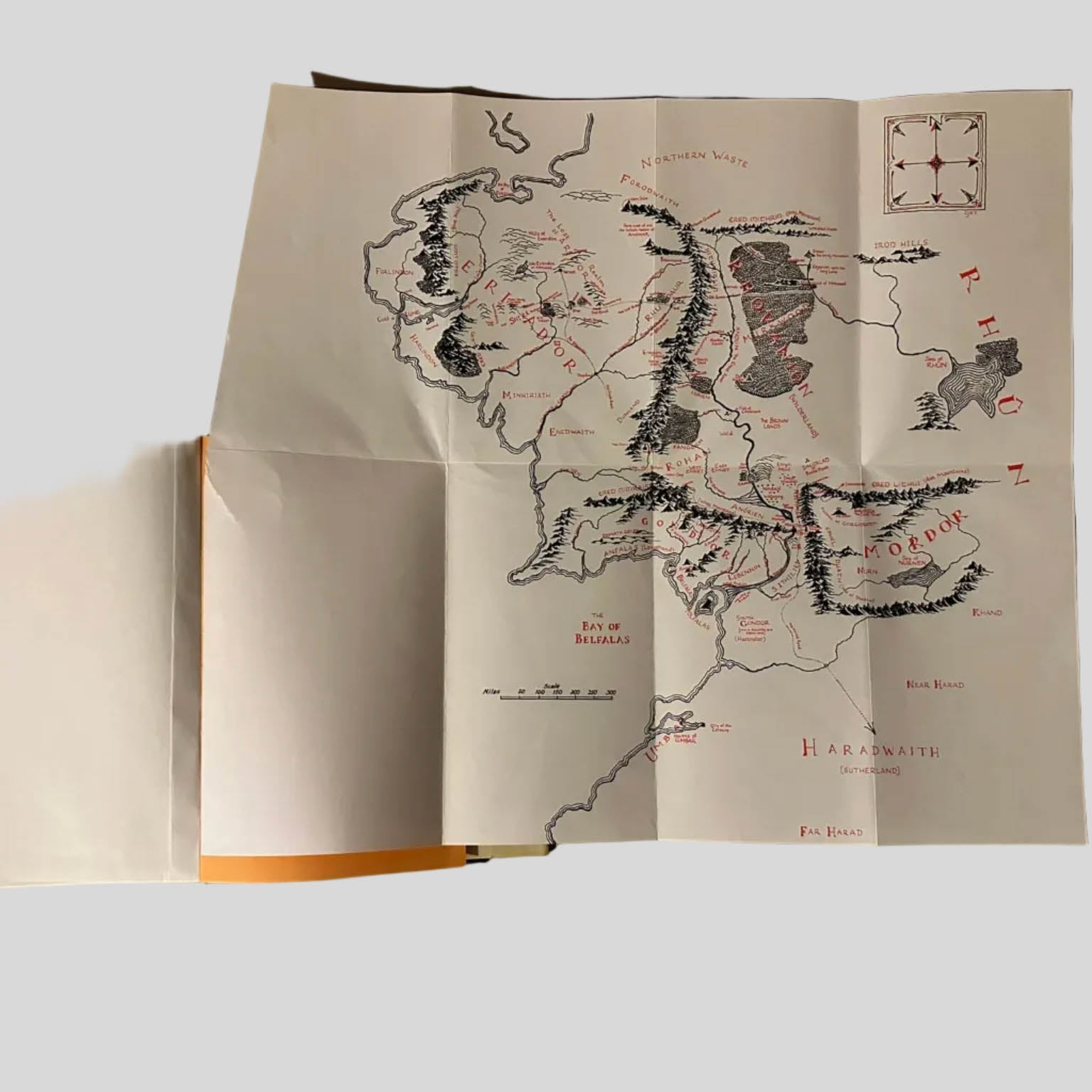 Large, folded Middle-earth map from the J.R.R. Tolkien 'Lord of the Rings' box set, featuring detailed red and black typography and geographical landmarks like Eriador and Mordor.