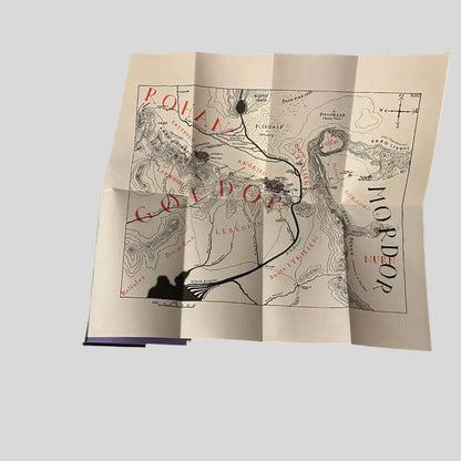 Folded Middle-earth map from J.R.R. Tolkien's Lord of the Rings box set, featuring detailed red and black typography for regions like Rohan, Gondor, and Mordor.