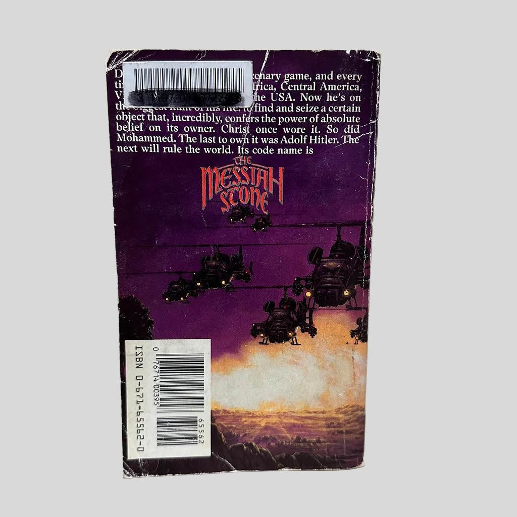 Back cover view of The Messiah Stone by Martin Caidin centered on a neutral light gray background. Back cover shows chipping and creasing. Library barcode sticker in the top left corner.