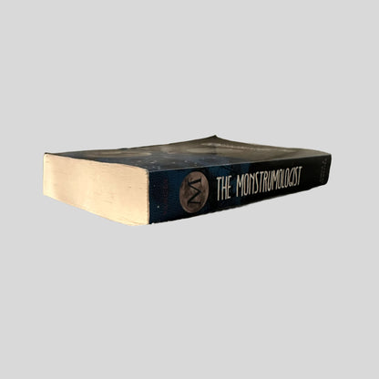 Close-up spine view of The Monstrumologist by Rick Yancey centered on a neutral light gray background. 