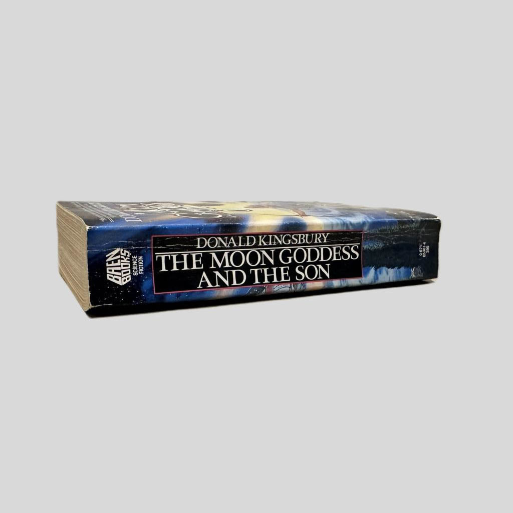 Close-up spine view of The Moon Goddess and the Son by Donald Kingsbury centered on a neutral light gray background. Spine shows minimal creasing. Pages lay flat.