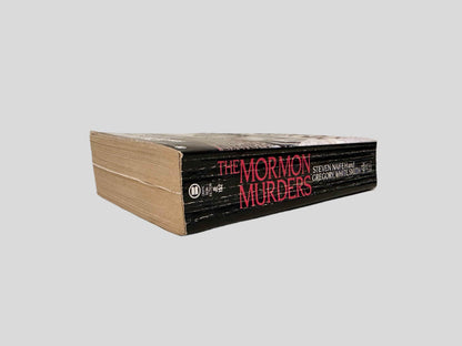 Close-up spine view of The Mormon Murders by Steven Naifeh & Gregory White Smith centered on a neutral light gray background. Spine is square and shows creasing.