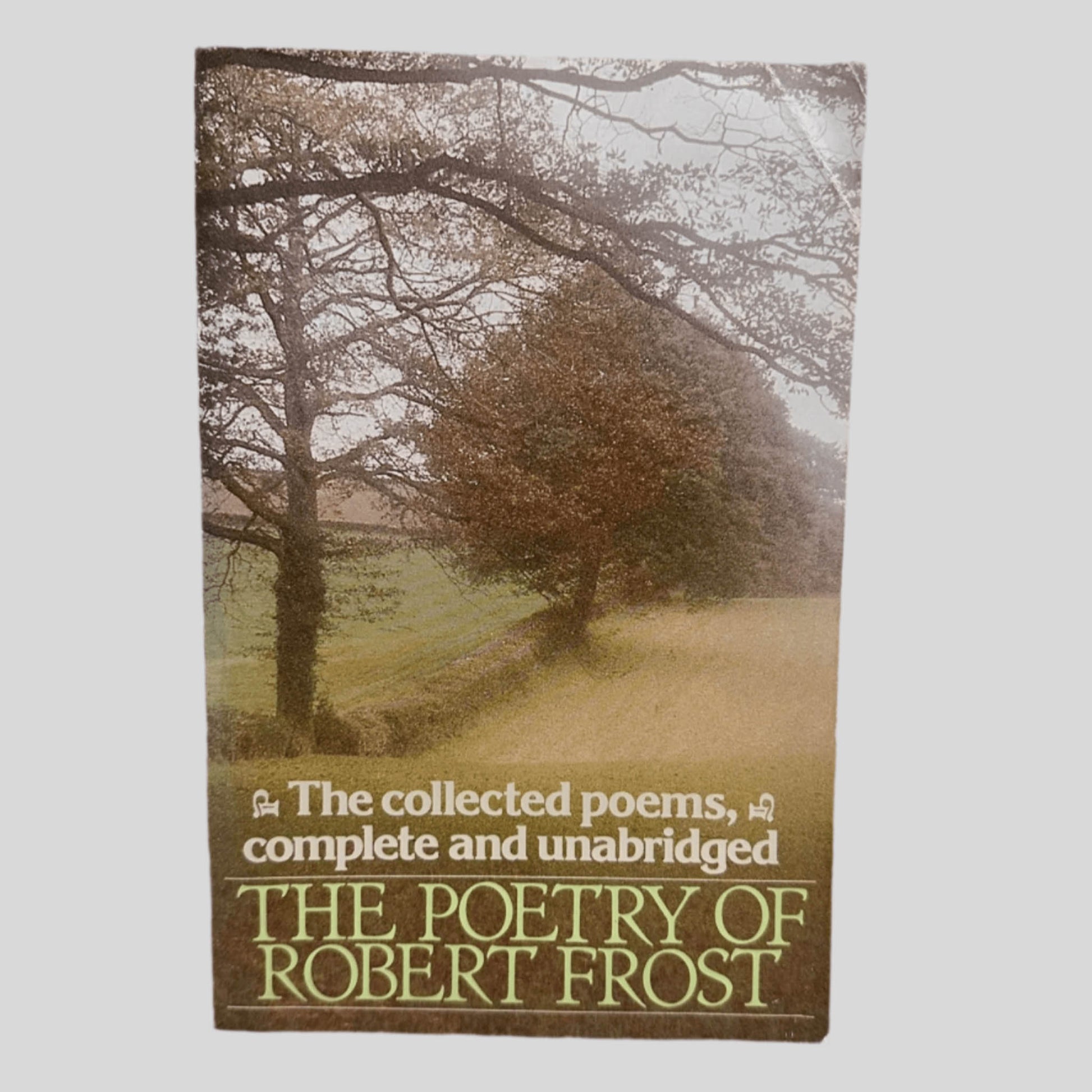 Front cover view of The Poetry of Robert Frost: The Collected Poems, Complete and Unabridged centered on a neutral light gray background. Crease in the top right corner.