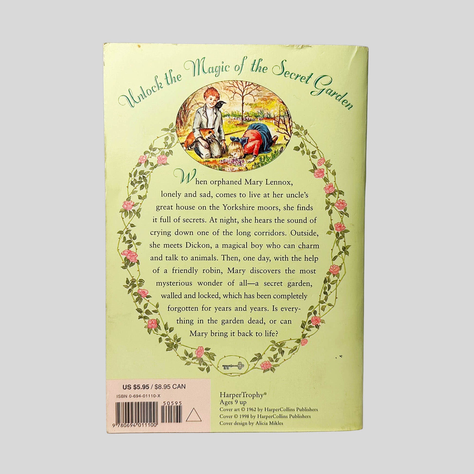 Back cover view of The Secret Garden by Frances Hodgson Burnett centered on a neutral light gray background. Creasing and chipping present along the top edge. Cover art is vibrant.