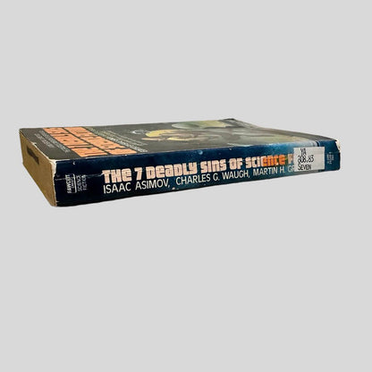 Close-up spine view of The Seven Deadly Sins of Science Fiction Edited By Isaac Asimov centered on a neutral light gray background. Spine is square and shows creasing; chipping at the top and lower end of the spine. Library shelving sticker attached to the lower end of the spine. Pages lay flat.