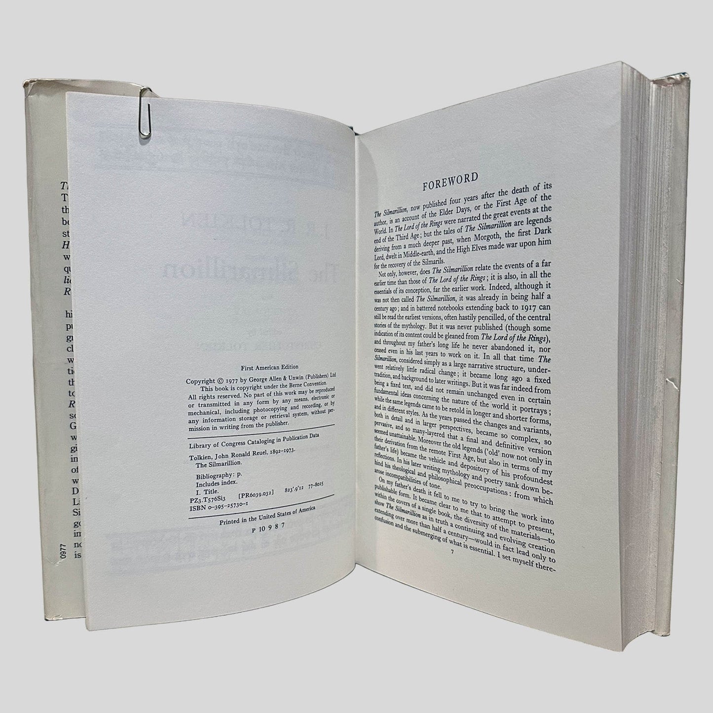 Interior view of a hardcover edition of The Silmarillion, displaying the copyright page and the "Foreword" by Christopher Tolkien. The screen shows the 1977 copyright date and original George Allen & Unwin publishing credits, marking it as a significant early printing. Part of the curated Fehmerling Books collection, this high-resolution image documents the sharp, uncreased state of the binding and the authentic typographic style of the era.