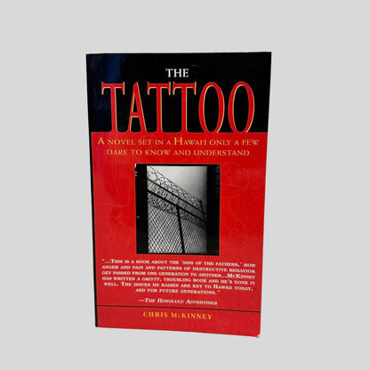 Front cover view of The Tattoo by Chris McKinney centered on a neutral light gray background. 
