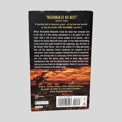 Back cover view of The Wailing Wind by Tony Hillerman centered on a neutral light gray background. Minimal chipping present along the top edge of the back cover.