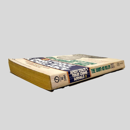 Close-up spine view of The Want-Ad Killer by Andy Stack centered on a neutral light gray background. Spine shows creasing.
