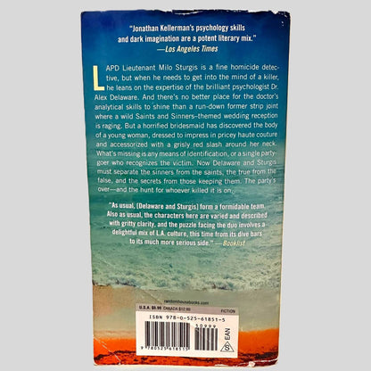 Back cover view of The Wedding Guest by Jonathan Kellerman centered on a neutral light gray background. Chipping along top and bottom edges. Crease across the bottom left corner.