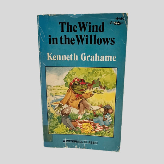 Front cover view of The Wind in the Willows by Kenneth Grahame centered on a neutral light gray background. Significant creasing and chipping around the edges. The cover art is vibrant and intact. This is a well loved copy.