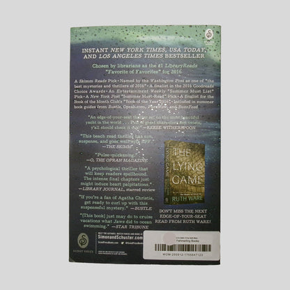 Back cover view of The Woman In Cabin 10 by Ruth Ware centered on a neutral light gray background. Small crease to the bottom left hand corner. 