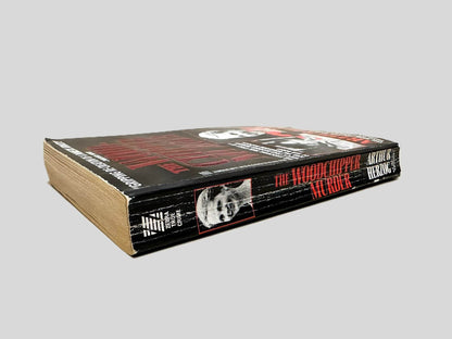 Close-up spine view of The Woodchipper Murder by Arthur Herzog centered on a neutral light gray background. Spine shows creasing.