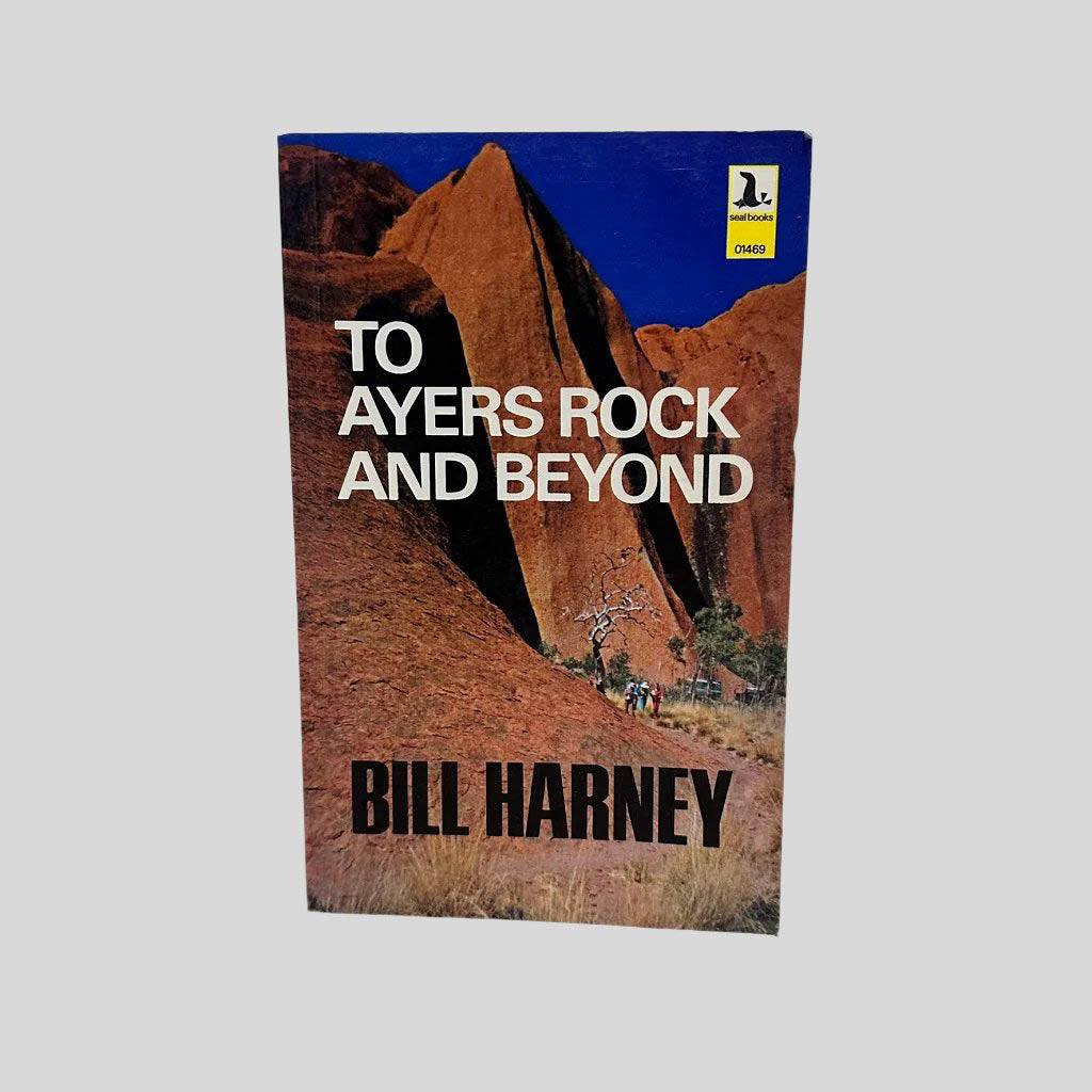 Front cover view of To Ayers Rock And Beyond by Bill Harney centered on a neutral light gray background. Minor chipping in the top right corner. Colors are vibrant.