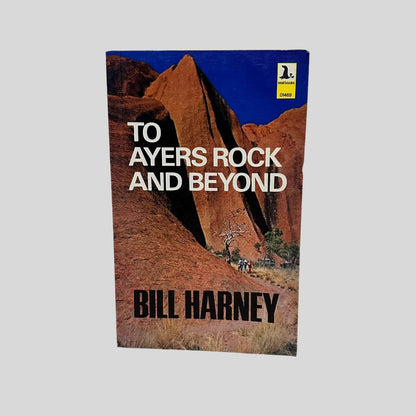 Front cover view of To Ayers Rock And Beyond by Bill Harney centered on a neutral light gray background. Minor chipping in the top right corner. Colors are vibrant.