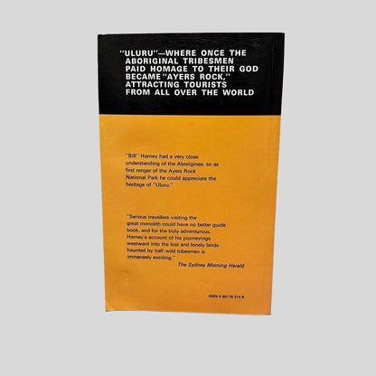 Back cover view of To Ayers Rock And Beyond by Bill Harney centered on a neutral light gray background. Crease in the bottom left corner. 