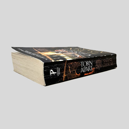 Close-up spine view of Torn Apart by Shane Gericke centered on a neutral light gray background. Spine shows creasing. Pages lay flat.