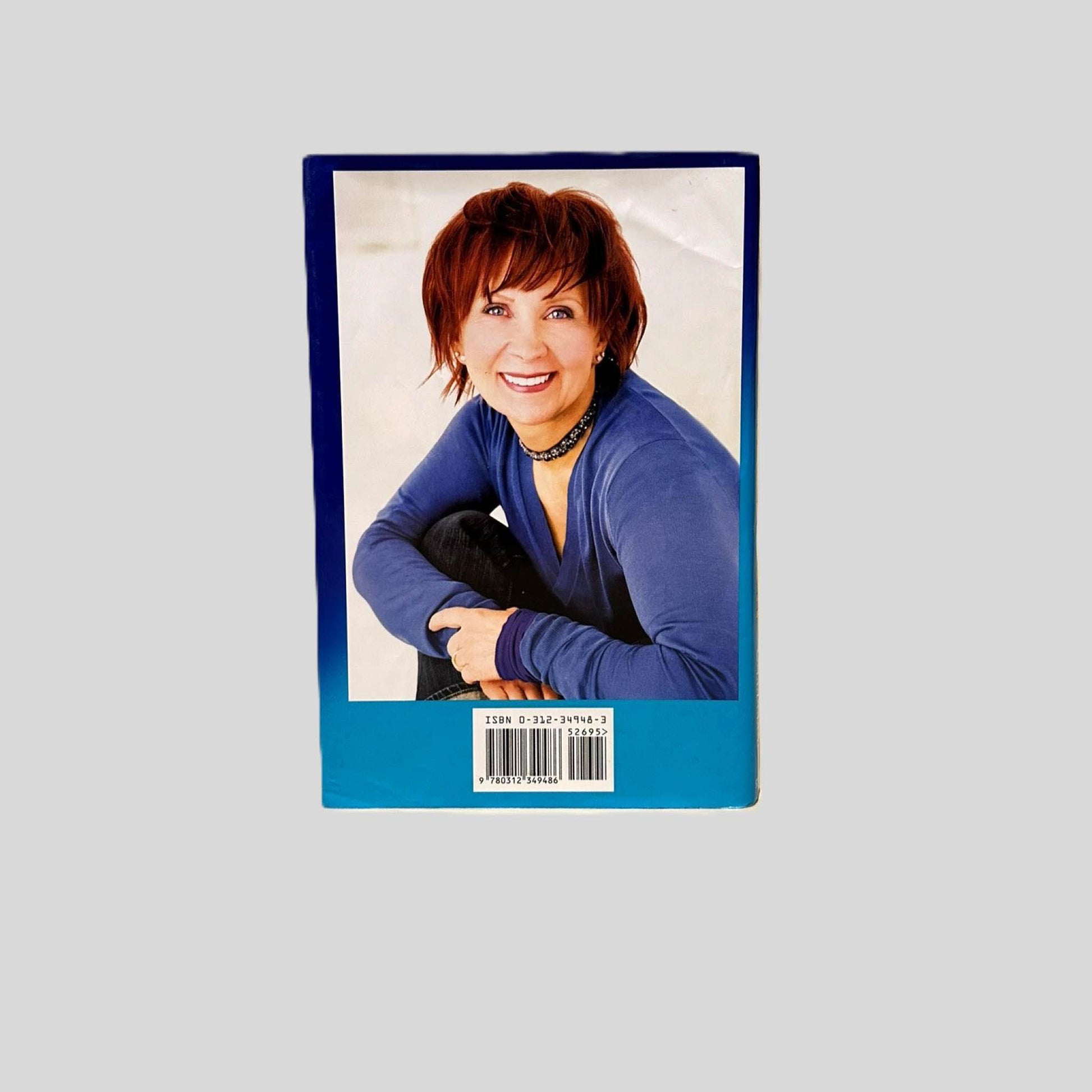 Back cover view of Twelve Sharp by Janet Evanovich centered on a neutral light gray background. Dust jacket is present and shows creasing on the top half.