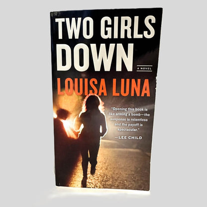 Front cover view of Two Girls Down by Louisa Luna centered on a neutral light gray background. Minor chipping on cover page edge.