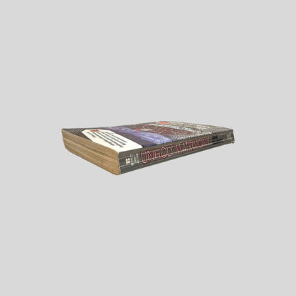 Close-up spine view of Unholy Matrimony by John Dillmann centered on a neutral light gray background. 