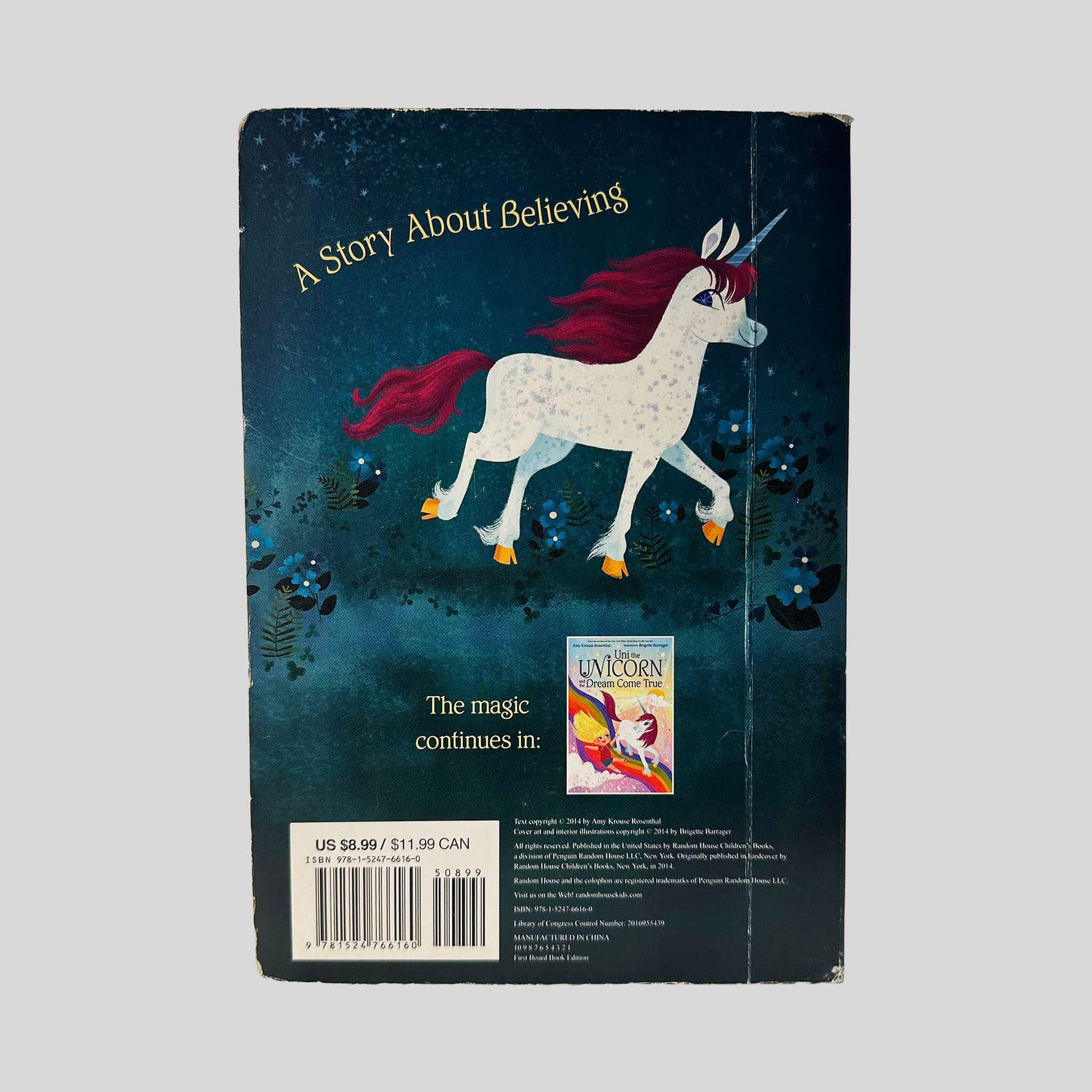 Back cover view of Uni the Unicorn by Amy Krouse Rosenthal centered on a neutral light gray background. Creasing near the spine edge. Chipping is present around the edges and corners from normal wear.