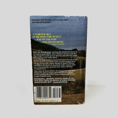 Back cover view of Walk Across America by Peter Jenkins centered on a neutral light gray background. Chipping most present in the top right edge and bottom right corner. Creasing across bottom left corner.