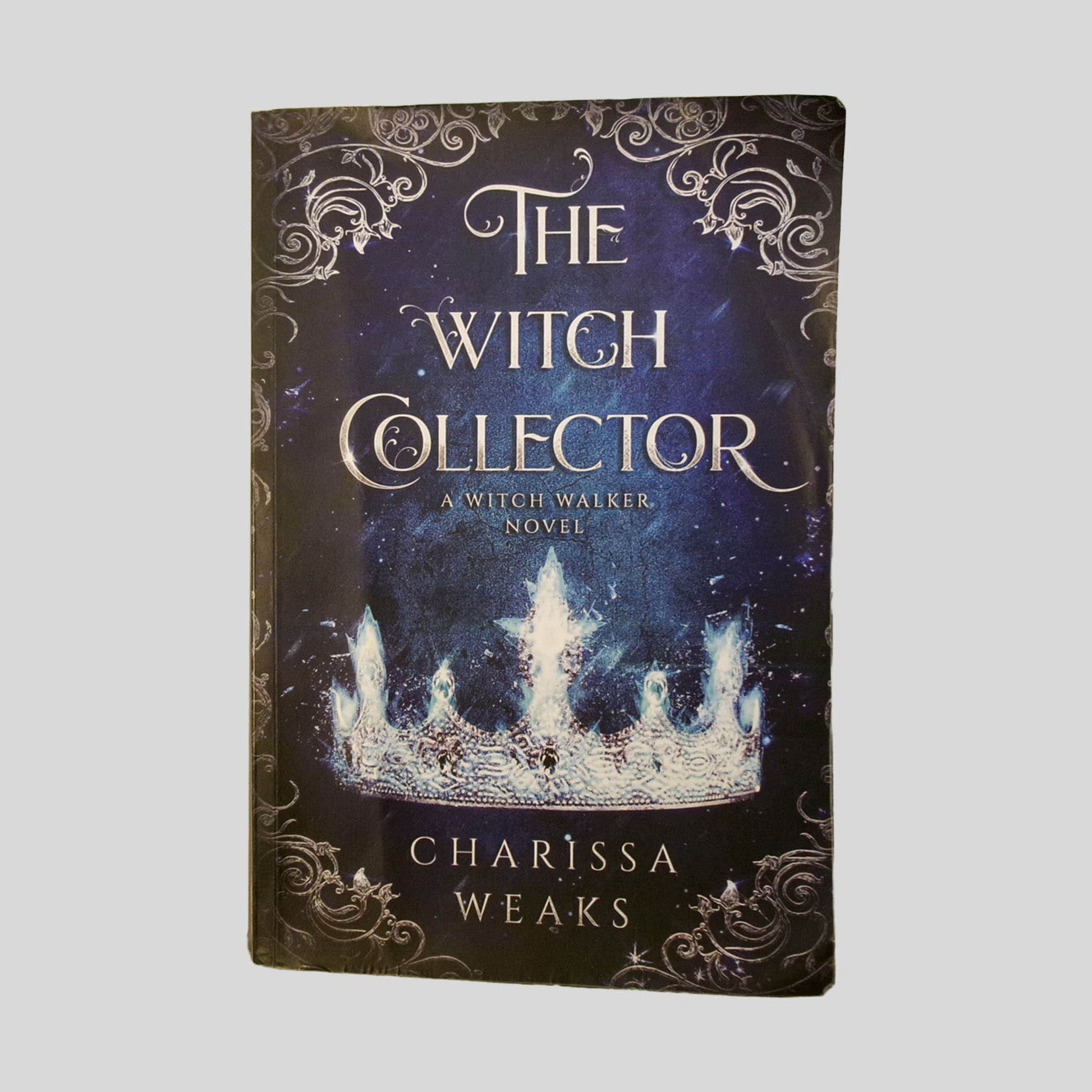 Front cover view of Witch Collector by Charissa Weaks centered on a neutral light gray background. Creasing and chipping are present around the edges.