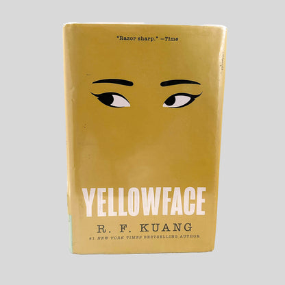 Front cover view of Yellowface by R. F. Kuang centered on a neutral light gray background. Dust jacket is present and pristine, wrapped in a mylar cover.