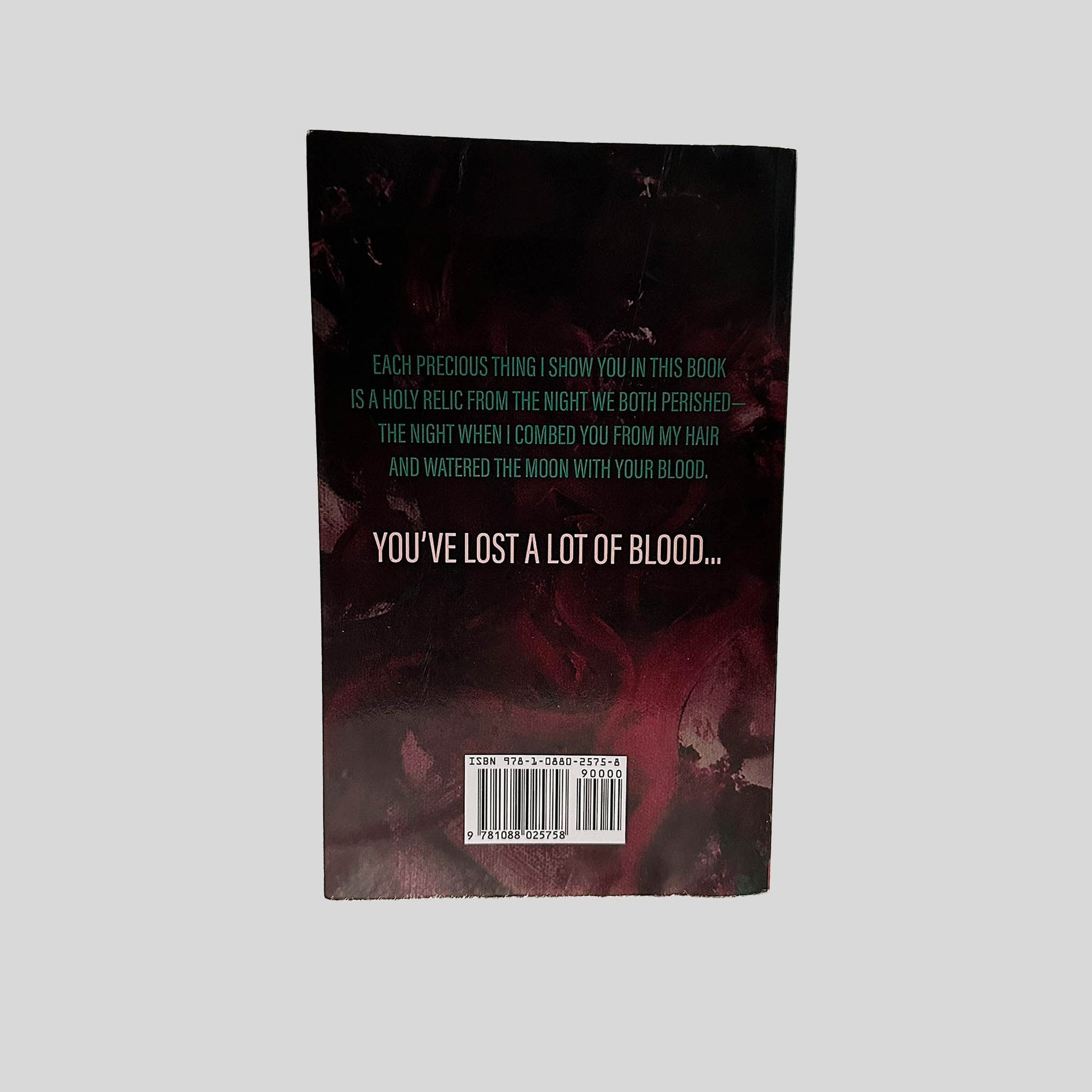 Back cover view of You've Lost A Lot of Blood by Eric LaRocca centered on a neutral light gray background. Chipping is present along the bottom edge of the back cover.