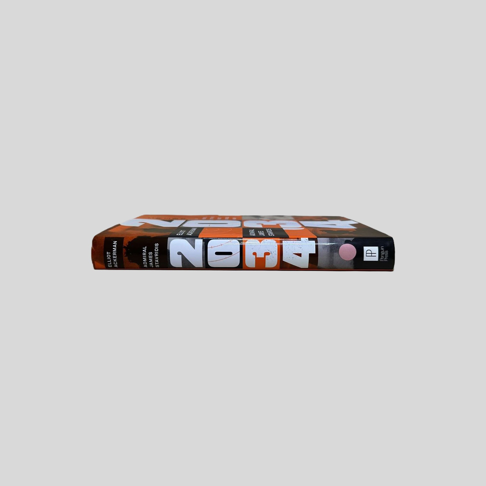 Spine of the 2034 hardcover by Elliot Ackerman and James Stavridis. Displays the title and authors in vertical orange and black lettering against a white background. The visual confirms the book's Very Good condition with a tight, uncreased binding.