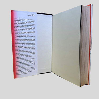 An open view of the front interior dust jacket flap of the hardcover novel 'Gone Girl' by Gillian Flynn. The text begins with the chilling hook 'Marriage can be a real killer' and provides a detailed synopsis of the disappearance of Amy Dunne in North Carthage, Missouri. The layout showcases the bold red and black typography of the Crown Publishers edition, documenting the pristine, collector-grade condition of this modern suspense masterpiece.