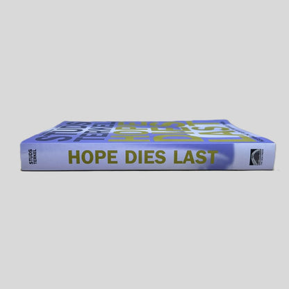 Side view of the paperback book 'Hope Dies Last' by Studs Terkel, showing the purple and blue spine with the title, author's name, and The New Press logo.