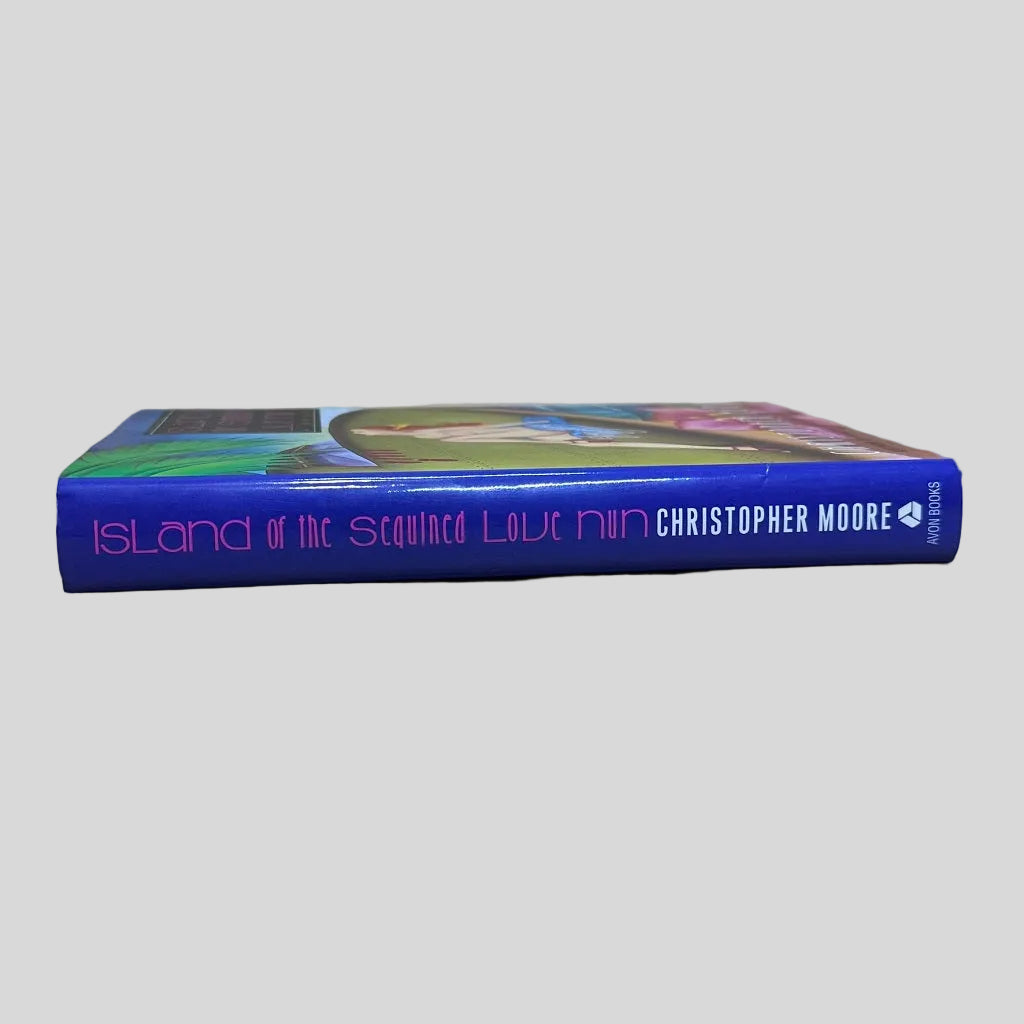 Spine and page edges of the humorous fiction book 'Island of the Sequined Love Nun' by Christopher Moore, highlighting the book's thickness and the Avon imprint on a light background.
