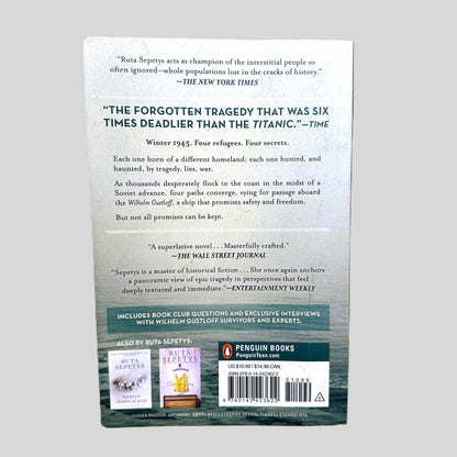 The back cover of the Penguin Books paperback edition of 'Salt to the Sea' by Ruta Sepetys. The layout features a haunting quote from Time describing the story as 'The forgotten tragedy that was six times deadlier than the Titanic'. The summary details the convergence of four refugees in Winter 1945 seeking passage on the Wilhelm Gustloff, documenting the excellent condition of this highly acclaimed YA novel.