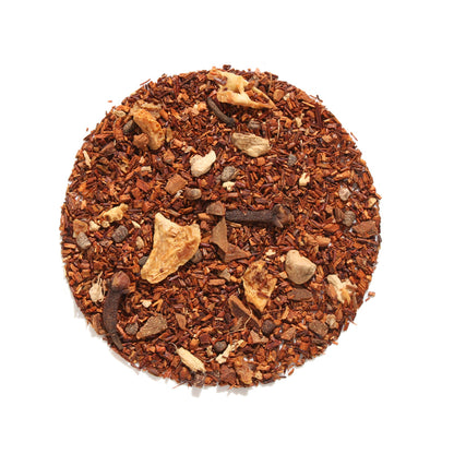 Top-down view of Autumn Almond Chai Herbal Tea loose-leaf blend arranged in a circle on a white background, displaying red rooibos, whole cloves, cinnamon bark, and dried almond pieces.