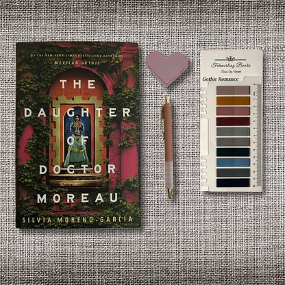 The book cover of 'The Daughter of Doctor Moreau' by Silvia Moreno-Garcia is displayed next to a heart-shaped leather bookmark, a pen and Gothic Romance annotation tabs from Fehmerling Books on a textured gray burlap background.
