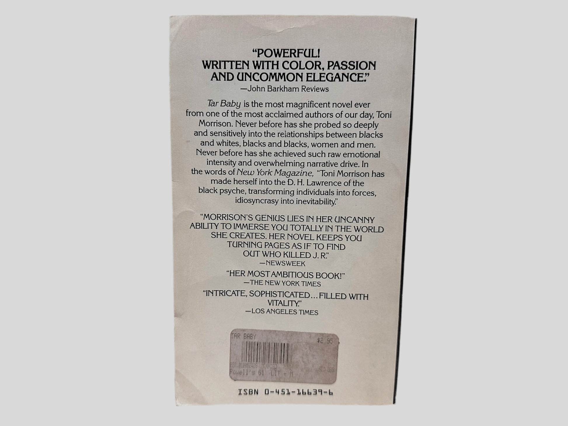 Back cover view of Tar Baby by Toni Morrison centered on a neutral light gray background. Creasing is present around the edges.