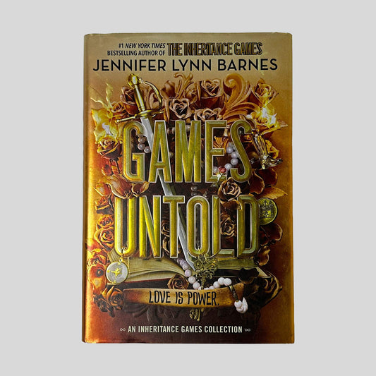 Front cover dust jacket of Games Untold by Jennifer Lynn Barnes in Like New hardcover condition, featuring gold metallic title lettering over warm amber and copper filigree art with roses, a sword, and pearl jewelry.