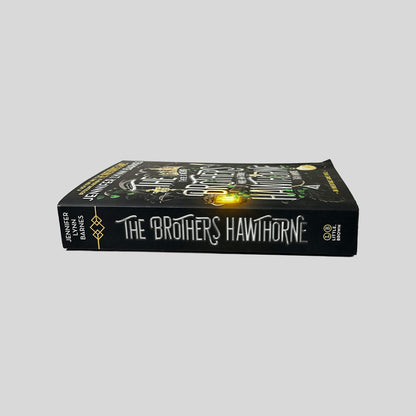 Unbroken spine view of The Brothers Hawthorne paperback by Jennifer Lynn Barnes displaying white title lettering, Little Brown publisher logo, crisp edges, and clean binding.