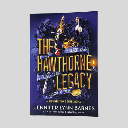 Front cover of The Hawthorne Legacy by Jennifer Lynn Barnes in Like New paperback condition, featuring bold gold typography over deep royal blue artwork with dark roses and jeweled keys.