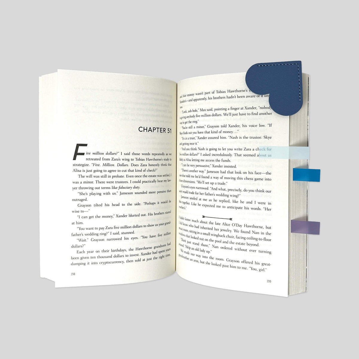 Close-up angled view of Slate Blue leather heart bookmark on open novel with Dawn to Dusk annotation tabs by Fehmerling Books.