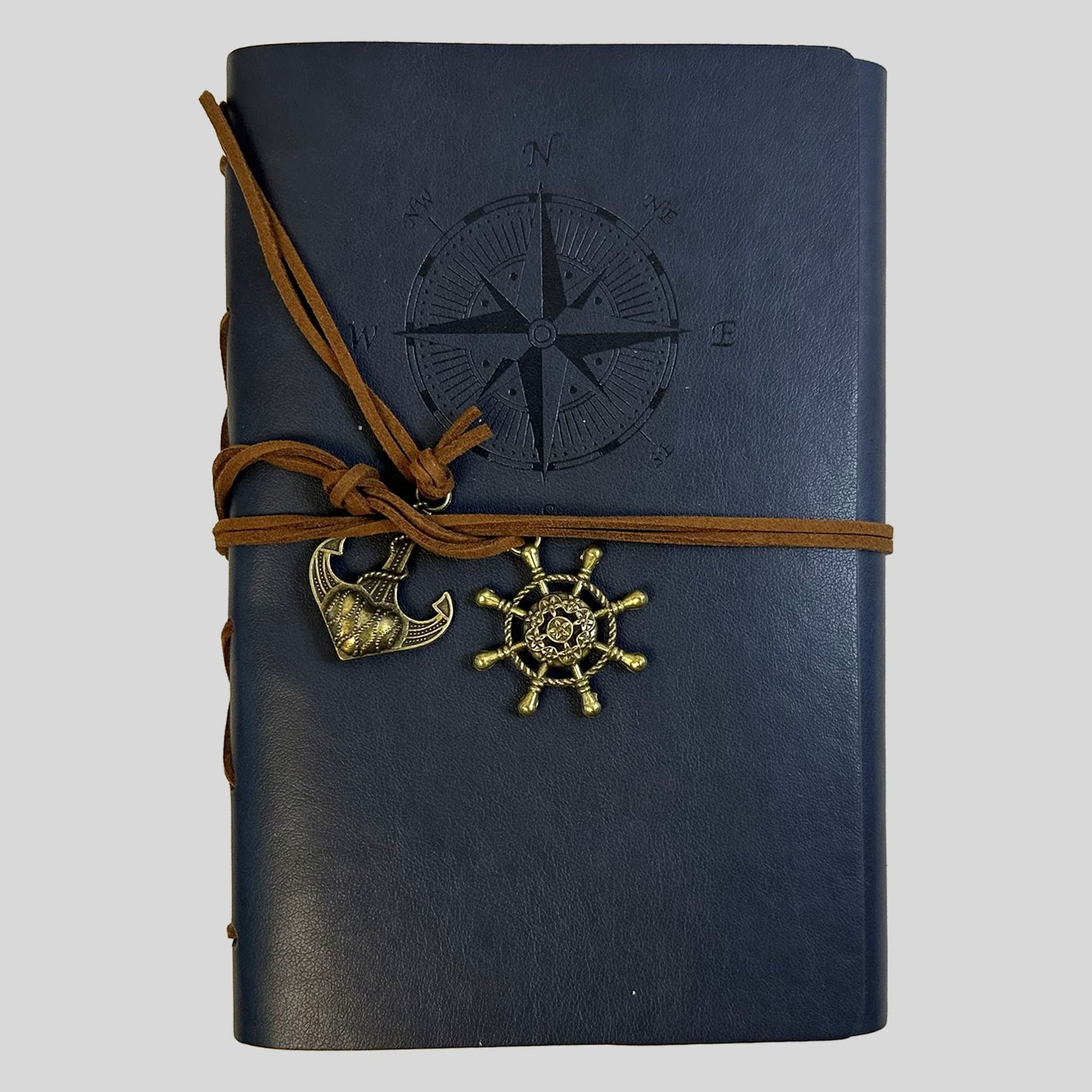 Front cover of a nautical-themed journal in deep navy, featuring a debossed maritime compass design. Isolated on a clean background, the image highlights the tactile details of the wrap-around closure and decorative metal charms. This professional view reflects the scholarly and timeless aesthetic of Fehmerling Books, offering an evocative tool for readers and writers who value vintage craftsmanship.