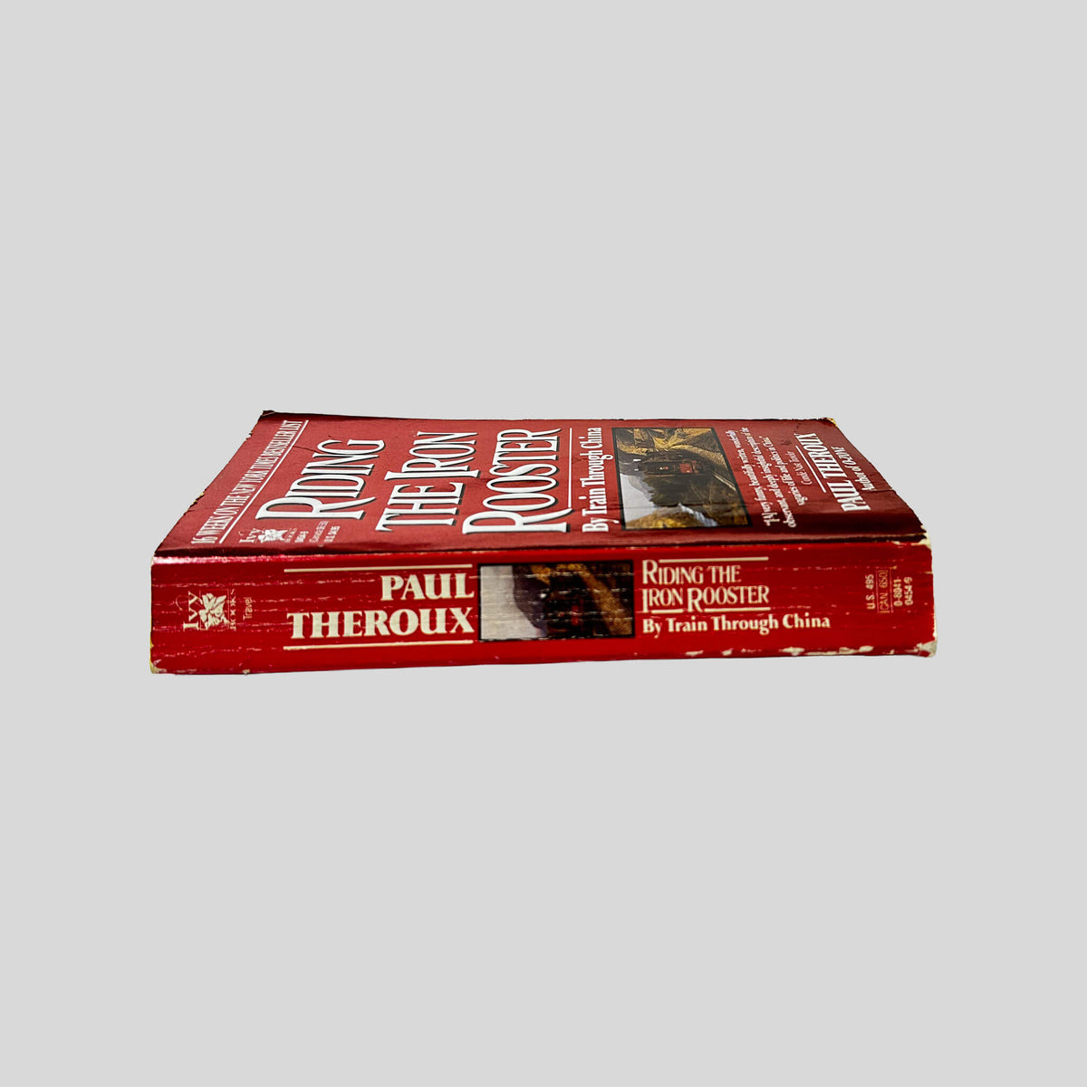 Spine view of Riding the Iron Rooster vintage used paperback edition by Paul Theroux.