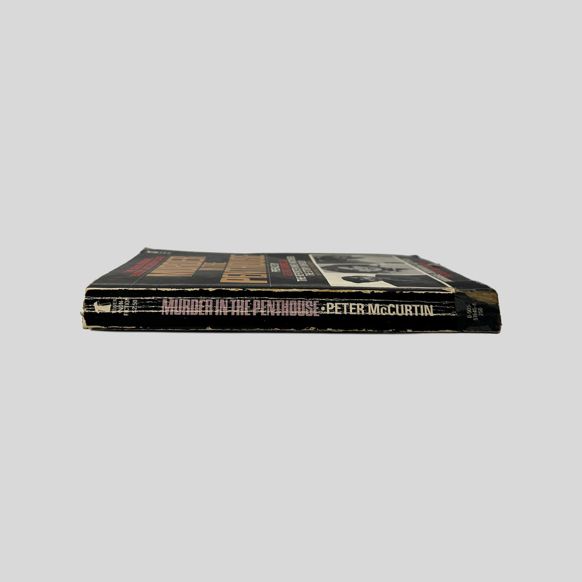 Spine view of Murder In The Penthouse vintage Tower Publications mass market paperback edition by Peter McCurtin.